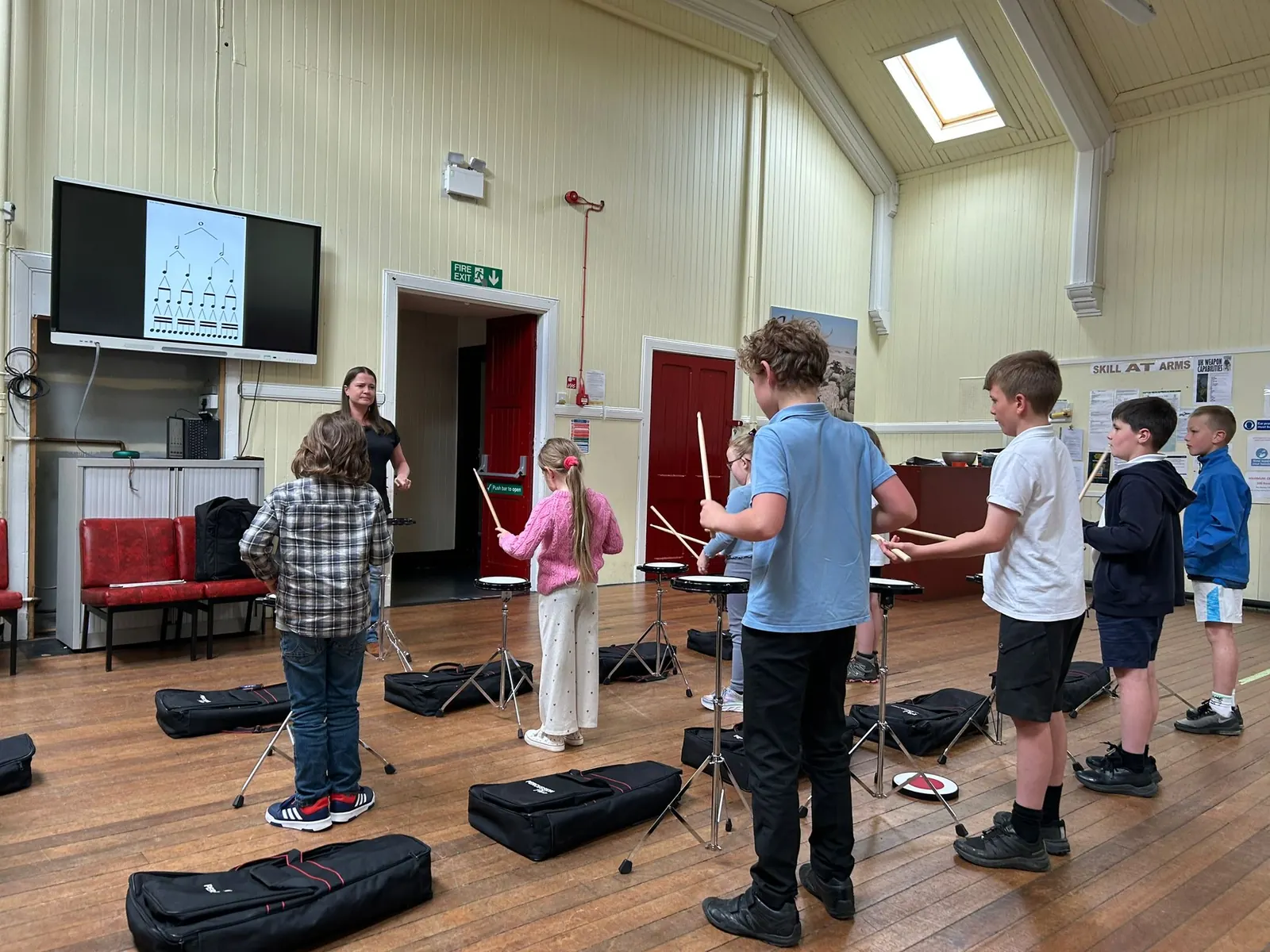 Students practising drum kit technique on practice pads with Seonaid