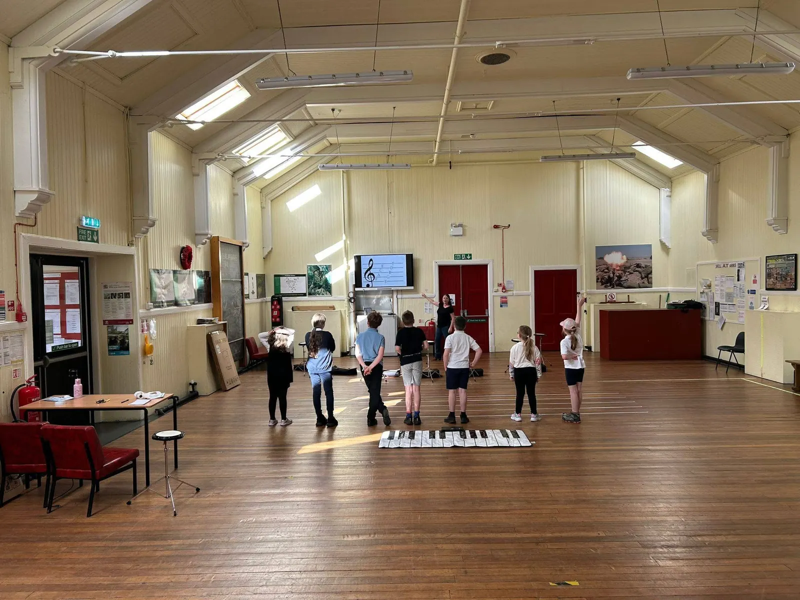 Seonaid leading a workshop with young students in a community hall